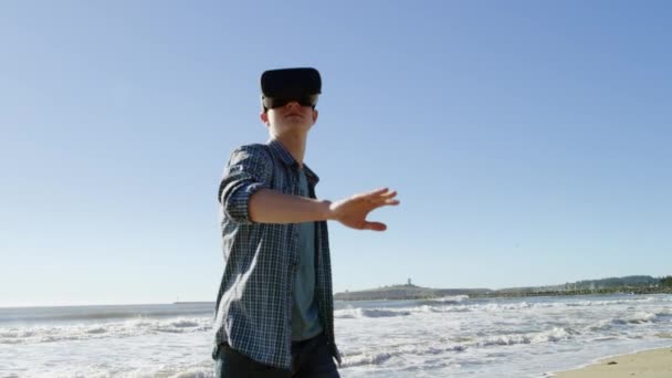 Молодой человек гуляет по тихоокеанскому пляжу — стоковое видео