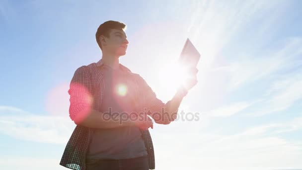 Jonge knappe met een tablet pc op een kust — Stockvideo