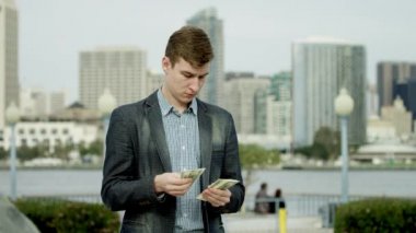 Genç zengin adam parasını Coronado bir sokakta sayıyor