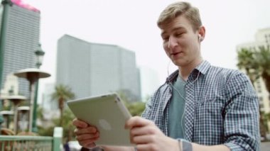 Çekici adam video çeviri için arkadaşları duran bir kaldırımda onun tablet pc kullanarak yapıyor