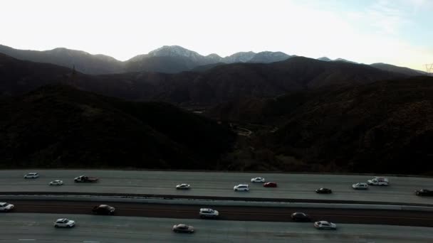 Luftaufnahmen über den felsigen Bergen und der Autobahn — Stockvideo