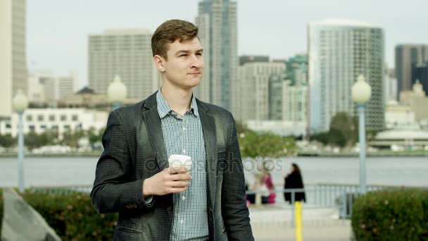 Young handsome is drinking tea on a sidewalk — Stock Video