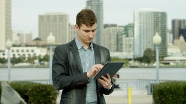 Genç adam bir kaldırım ve onun arkadaşı için bekleyen bir tablet pc ile