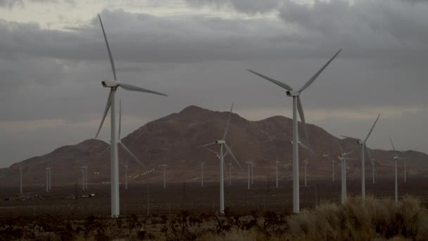 El hermoso paisaje de molinos de viento con montañas masivas en el fondo — Vídeos de Stock