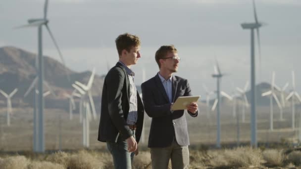 Die Männer sprechen über das Projekt im Bereich der Windräder — Stockvideo