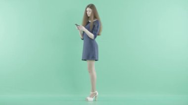 bir kadın bir kart ve bir akıllı telefon elinde tutan