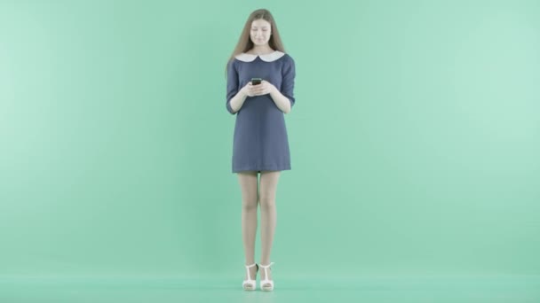 Eine Frau im blauen Kleid tippt Botschaften — Stockvideo