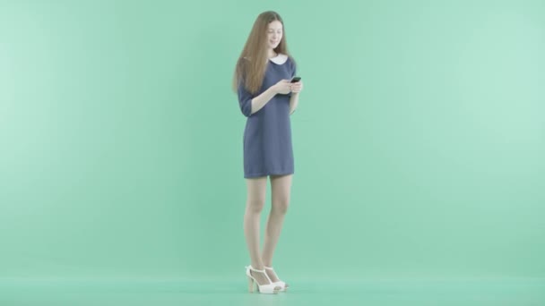 笑顔の素敵な女の子立っているスマート フォン上にテキスト メッセージ — ストック動画
