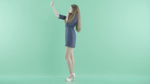 Uma menina de vestido fica fazendo selfies — Vídeo de Stock