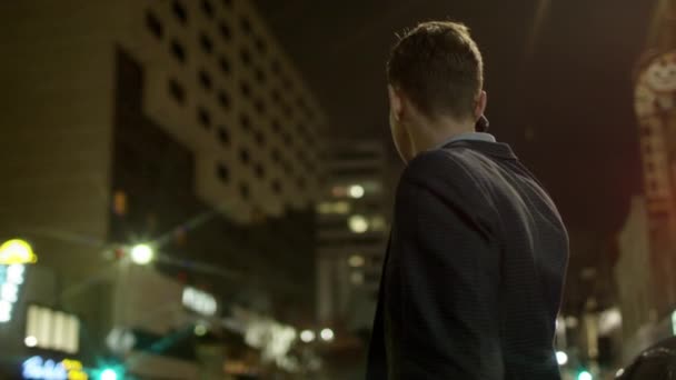 Estudante bonito está falando por um celular em uma rua à noite — Vídeo de Stock