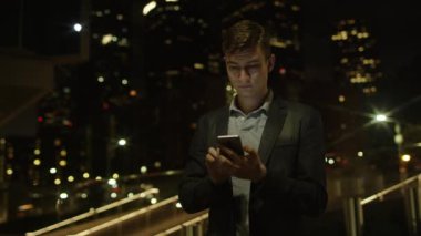 Yakışıklı genç turist onun smartphone bir sokakta duran sosyal ağlar için kullanıyor