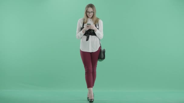 A nice woman stands texting and smiling — Stock Video