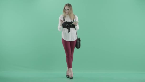 A woman in glasses holds a card and a bundle of cash — Stock Video