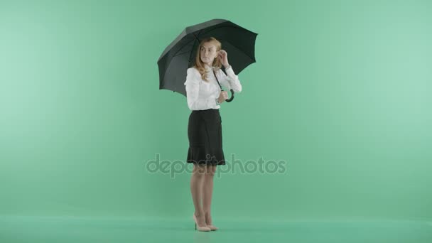 Ένα κορίτσι στέκεται κάτω από ομπρέλα και περιμένει — Αρχείο Βίντεο
