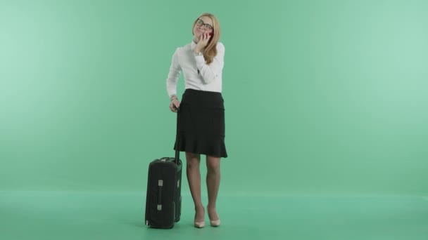 A woman has a phone call holding a luggage — Stock Video