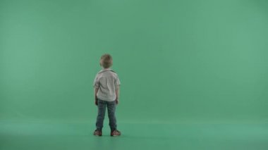 Küçük çocuk karşı yeşil arka plan atlama