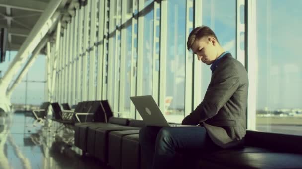 Jonge student met een laptop in de luchthaven van Londen — Stockvideo