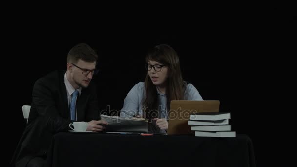 Ung man och kvinna diskutera ett papper — Stockvideo