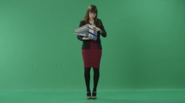 Sekreter klasörlerin elinde bir deste ile onlardan biri açar ve bir kağıt okuma başlar