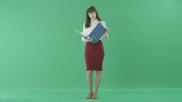 Молодая женщина просматривает синюю папку в руках — стоковое видео