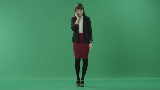 Young worried business lady stands talking on a mobile phone — Stock Video