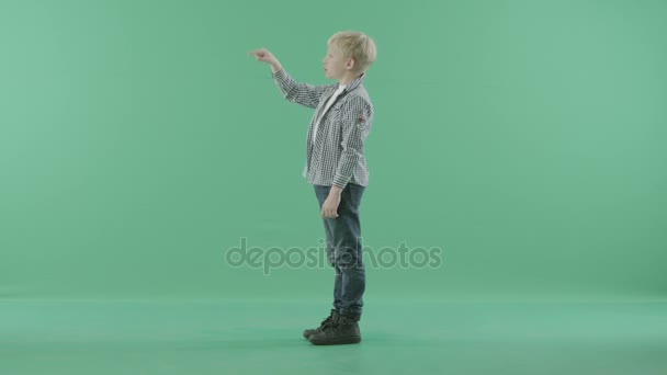 Νεαρό αγόρι στέκεται πλάι αγγίζοντας μια φανταστική οθόνη — Αρχείο Βίντεο