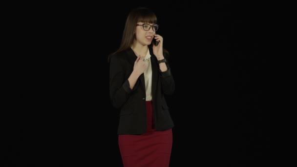Flicka klädd i en business-stil har en icke-arbetsrelaterade konversation på telefonen — Stockvideo
