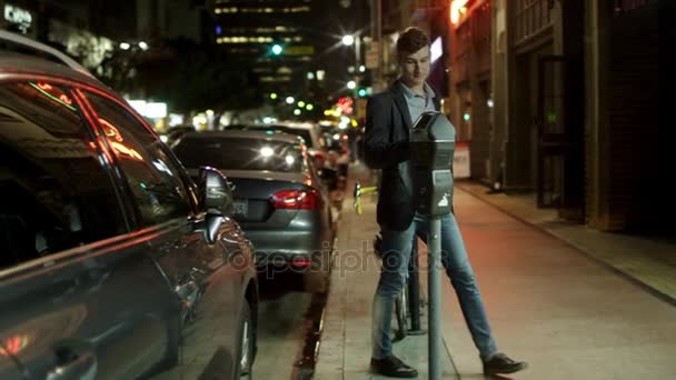 Молодий чоловік платить за паркінг на вулиці — стокове відео