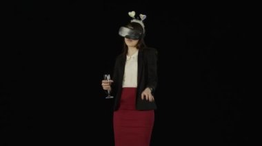 VR gözlük takan ve bir cam elinde tutan güzel kız dansları