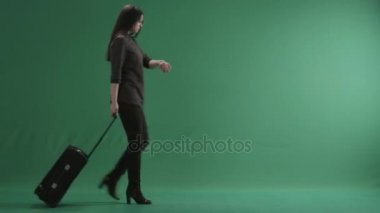 Bir bavul wheeling ve onun kol saati görünümlü esmer kadın