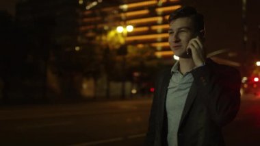 Genç yakışıklı adam onun smartphone üzerinde konuşmak ve bir taksi yakalamak için