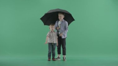 İki çocuk bir şemsiye ile ayakta