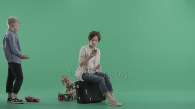 İki erkek anneleri bavula oturma etrafında oynarken