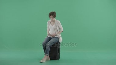Bavula oturan çekici hamile kadın