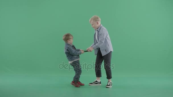 Two boys pulling a tablet pc in opposite directions — Stock Video