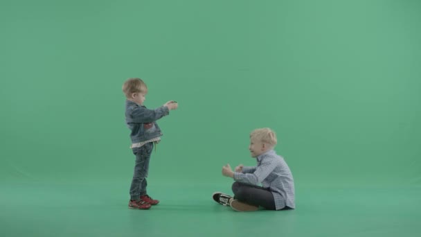 Klein jong geitje neemt foto's van de oudere broer van de hir — Stockvideo