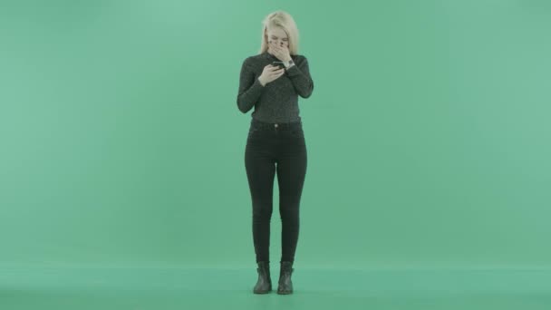 Ein Mädchen steht und schreibt eine SMS — Stockvideo