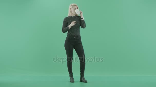 A blonde woman drinks from a mug thinking — Stock Video