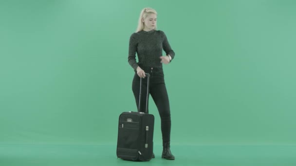 En kvinna står med bagage väntar — Stockvideo