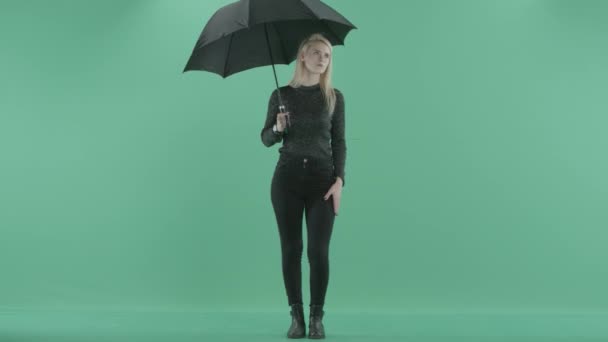 Una mujer está de pie bajo la lluvia con paraguas — Vídeo de stock