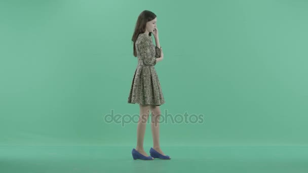 En söt tjej i klänning samtal på telefonen — Stockvideo