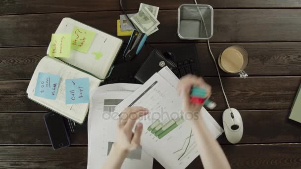 Vista superior. Um homem limpa a bagunça em sua mesa de trabalho — Vídeo de Stock