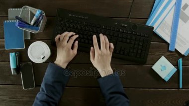 Üstten Görünüm vurdu. Bir adam sakin bir şekilde çalışmaları sırasında kahve içiyor