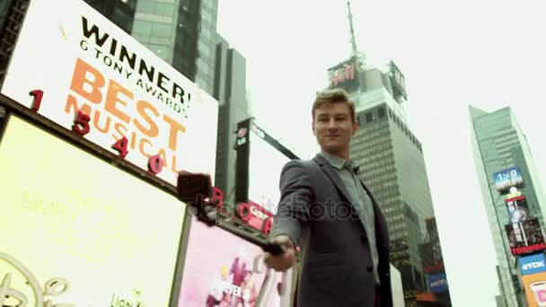 Young man on Times Square taking selfie with a selfie stick — Stock Video