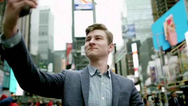 Ungdomlig stilig tar en bild av sig själv på Times Square — Stockvideo