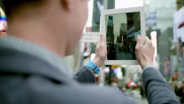 Jovem está tirando uma foto de Times Square em seu tablet pc — Vídeo de Stock