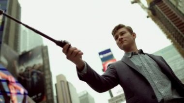 Genç adam bir selfie onun smarthpne üzerinde selfie stick kullanarak alma