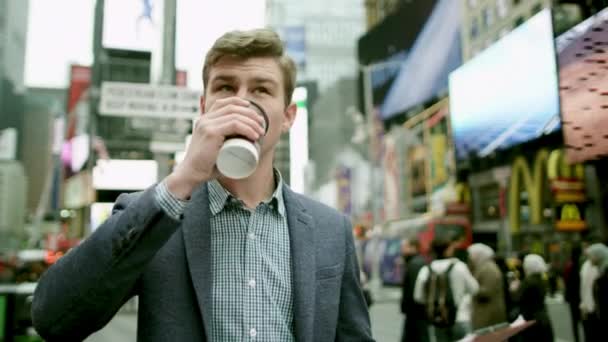 Jovem arquiteto com uma caixa de mapa e uma xícara de café na Times Square — Vídeo de Stock