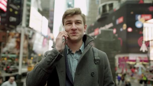 Fiatal turista beszél, mint a mobiltelefon, a Times Square — Stock videók