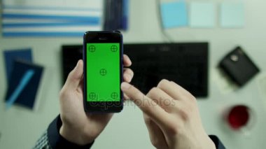 Üstten Görünüm vurdu. Bir adam sakin bir şekilde onun cep telefonu resimleri kaydırma